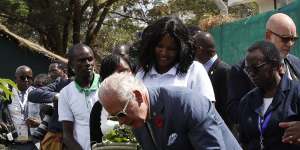 King Charles bends down to look at vegetables during his visit to City Shamba,an urban farming project in Nairobi.
