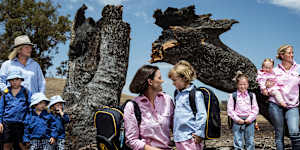Annabelle Cleeland and her five-year-old daughter Quinn (centre) with Lou Webb (left) and her children Tom and Fred,3,and George,6,and Felicity Jeffrey and her children Jemima,6,Sebastien,4 and Claudio,1,stand in the burnt out Jeffrey property in Whiteheads Creek. All three families’ homes were decimated by the Longwood fire.