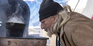 Hawk Palmour tends a fire he used for heat and cooking at a homeless camp in Austin,Texas.