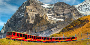 A tourist train travels down the mountain from Jungfraujoch station.