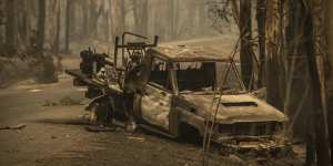 A firefighting Landcruiser lies burnt in Kangaroo Valley. It crashed after hitting a fallen tree on Saturday. 