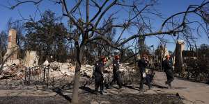 Members of a San Bernardino County Fire Department search and rescue crew work among the ruins of the Pacific Palisades neighbourhood of Los Angeles.