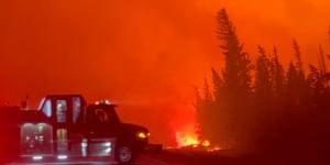 A vehicle is parked near a burning wildfire in Hay River,Canada,this week.