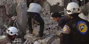 Syrian Civil Defense workers (known as White Helmets) search through the rubble after air strikes in the village of Hass in the Idlib province,Syria.