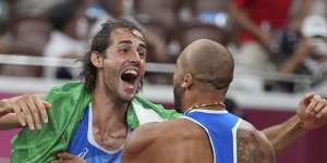 High jump gold medalist Gianmarco Tamberi,left,congratulates compatriot Lamont Marcell Jacobs.