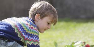 A child lays flowers outside Windsor Castle,where Prince Philip died.