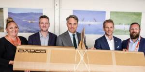 Defence Minister Richard Marles (centre) with SYPAQ team members and one of the cardboard drones.