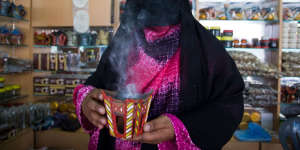 A veiled vendor at a frankincense shop at Al-Husn Souq in Salalah.