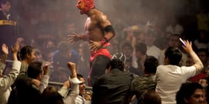 A lucha libre wrestler shouts to the crowd at Arena Mexico.