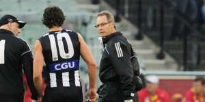 Scott Pendlebury in the hands of club doctors during the game against Gold Coast.