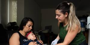 Veronica Carbone from Heartfelt Support Services helps Jennifer Brankin with the feeding of her 7-year-old son,Alexander,who has Joubert Syndrome.