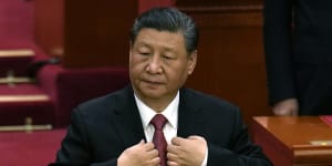 Chinese President Xi Jinping adjusts his jacket during the closing session of the National People’s Congress held at the Great Hall of the People in Beijing on Monday.