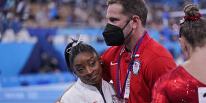 Coach Laurent Landi embraces Simone Biles after she quit the Team final at the Olympics.