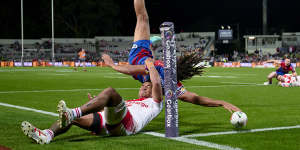 Roosters-bound former Newcastle winger Dominic Young flips over the try line to score against the Dragons.