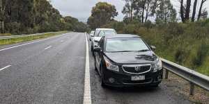 Cars stranded on the side of the Hume Freeway after hitting huge potholes.