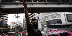 Gratitude,admiration and goodbye:a protester gives the three-finger salute during a demonstration outside a Bangkok shopping mall.