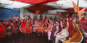 Hindus shout religious slogans as they watch a live telecast on a giant screen the groundbreaking ceremony.