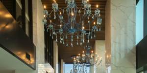 Sofitel’s indoor pool is softly lit by three blue chandeliers.