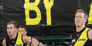 In memory:Richmond players run through the banner dedicated to AFL great Danny Frawley.