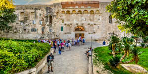 Tourists outside the ancient Golden Gate to the Diocletian's Palace section of the Old Town of Split,Croatia.
