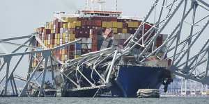 A Coast Guard cutter passes the Dali cargo ship stuck under the destroyed Francis Scott Key Bridge.