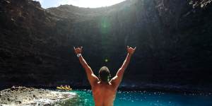 A man salutes the Pukalani Open Ceiling Cave in Kauai,Hawaii.