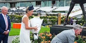VRC chairman Neil Wilson,chief executive Kylie Rogers and Greg Miles lay flowers.