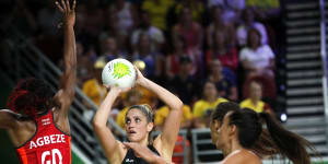 Te Paea Selby-Rickett of New Zealand,centre,and Ama Agbeze of England,left,compete during the preliminary round netball game.