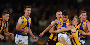 Elijah Hewett kicks the ball under pressure during clash between Hawthorn and West Coast at Marvel Stadium on Sunday.