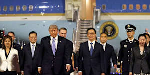 US President Donald Trump is greeted by Chinese youth,a military honour guard and military band as he arrives at Beijing Capital International Airport on Wednesday.