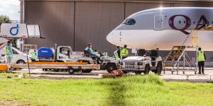 Biosecurity and airport staff in PPE gather around a Qatar Airways chartered flight carrying tennis players and staff into Melbourne on Thursday.