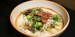 The chicken and mushroom congee is topped with fried leek,garlic and a swig of sesame oil and soy. 
