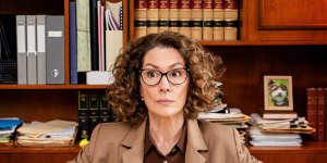 Kitty Flanagan as the brown-suited probate lawyer Helen Tudor-Fisk.