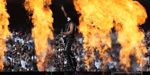 Paul Stanley is dwarfed by a wall of flames as KISS perform at the AFL grand final.