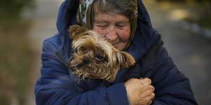 A woman warms her dog in the Ukrainian town of Kivsharivka,as temperatures fall in eastern Europe.