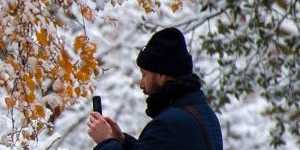 A visitor takes pictures of a snow covered Regent’s Park in London on Monday.