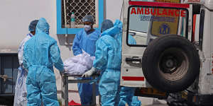 Health workers move the body of a COVID-19 victim at a mortuary in New Delhi on Wednesday.