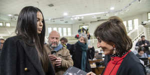 Karima el-Mahroug,aka Ruby Rubacuori,one of the women who attended the bunga bunga infamous parties,presents her book to prosecutor Tiziana Siciliano,right,at the trial’s in the bunker room of Milan’s San Vittore jail.