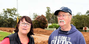 Echuca East neighbours Julie Golledge and Peter Mitchell at the levee under construction in front of their properties. The levee will protect homes on the other side of the street but could leave theirs in the “Murray pool”.