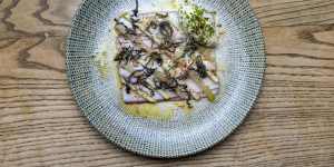 Smoked eel is plated as a perfect square and topped with apple and pickled kohlrabi.