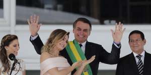 Brazil's new first lady Michelle Bolsonaro points at her husband,Brazil's new President Jair Bolsonaro,after she gave her speech in sign language.