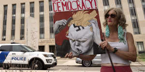 Voter Nicky Sundt holds a banner outside the Federal District Court this week.