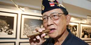 Former Philippine President Fidel Ramos bites his cigar.