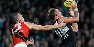 Jeremy Finlayson takes a mark under pressure from Essendon’s Nik Cox.