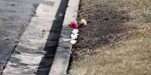 Flowers are left at the scene of the car fire.