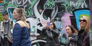 Visitors to Hosier Lane stream past the junction of Rutledge Lane where some drug usage occurs.