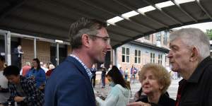 NSW Premier Dominic Perrottet speaking with voters at a polling booth in Bennelong on Saturday.