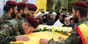 A Hezbollah fighter kisses the coffin of Ali Bazzi,who was killed in the airstrike.