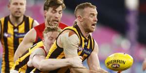 Tom Mitchell handballs as Clayton Oliver tackles.