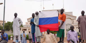 Supporters of mutinous soldiers hold a Russian flag as they protest in Niamey,Niger.